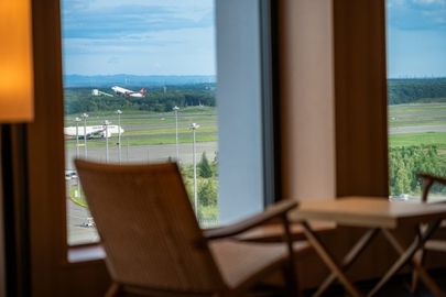 東側客室から望む国内線ターミナルと滑走路、離陸する飛行機の眺め