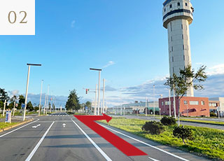 通過國際線航廈之後會看見右方的機場管制塔台，請於塔台正下方的紅綠燈右轉。